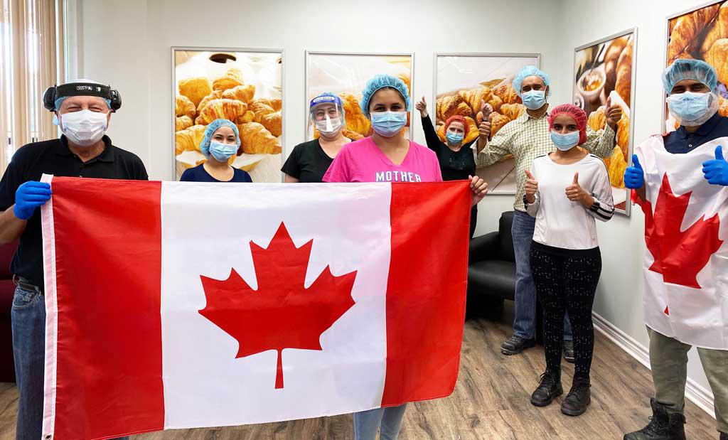 Upper Crust team members holding a Canadian Flag